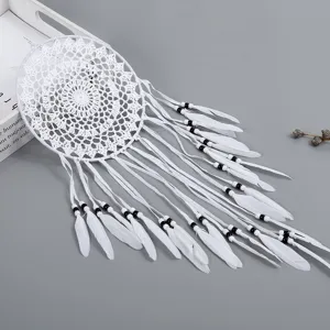 Attrape-rêves mural blanc en macramé avec plumes et perles pour décoration intérieure bohème.
