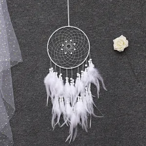 Vue détaillée du attrape-rêves blanc avec plumes et perles délicates pour décoration murale.