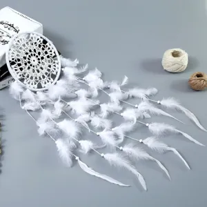 Detailopname van witte veren dromenvanger met fijn kantweefsel en hangende kralen.