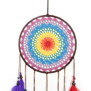 Détail d'attrape-rêves au crochet multicolore fait main avec fil arc-en-ciel et perles.