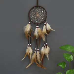 Nahaufnahme eines Traumfängers im Indianer-Stil mit braunen Federn und Perlen