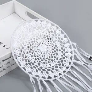 Attrape-rêves blanc en crochet avec rubans frangés pour décoration murale de chambre.