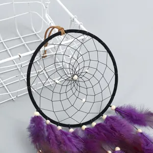 Handmade black dreamcatcher with purple feathers, elegant wall hanging decor for room.