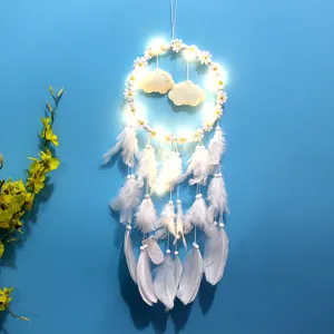 Gedetailleerd zicht op witte dromenvanger met madeliefjes en warme gloeiende LED-lichten