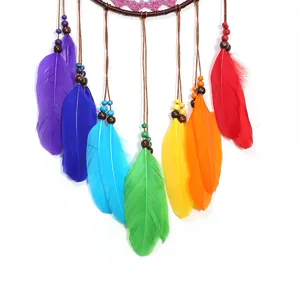 Attrape-rêves mural en plumes colorées fait main, détail de décoration intérieure boho.