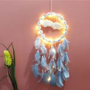 Detailweergave van een verlichte dromenvanger met blauwe veren en een madeliefjesring.