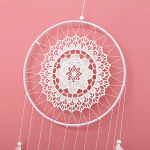 Nahaufnahme des weißen Spitzen Traumfängers mit Federn, schöne Boho-Wanddekoration zu Hause.