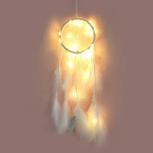 Dettaglio acchiappasogni bianco fatto a mano con piume e luci LED, decorazione romantica da parete.