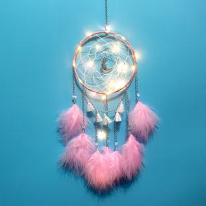 Nahaufnahme eines rosa Traumfängers mit leuchtenden LED-Lichtern und weichen Federn.