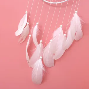 Nahaufnahme des rosa Feder Traumfängers, elegante Boho Wandbehang Heimdekor Detail.
