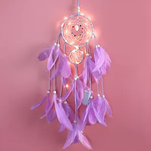 Detalle de atrapasueños morado artesanal con plumas suaves y luces LED cálidas.