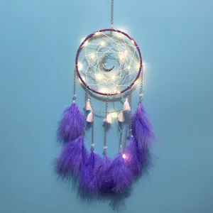 Detailaufnahme des lila Traumfängers mit Federn, LED-Lichtern und dekorativen Ketten.