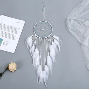 Detailweergave van handgemaakte witte dromenvanger met veren en blauwe kralen decor
