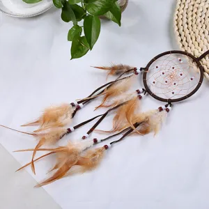 Vue détaillée d'un attrape-rêves marron fait main avec plumes naturelles et perles rouges