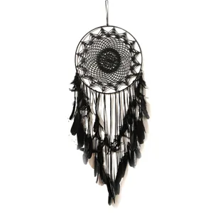 Close-up detail of the black dream catcher featuring intricate web and feather pendants.