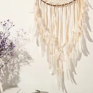 Detailansicht eines großen Boho-Traumfängers mit weichen weißen Federn und Bändern