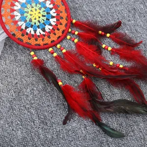Détail d'un attrape-rêves fait main coloré avec plumes rouges et perles décoratives