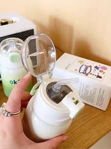Gros plan sur le détail de la paille de la gourde enfant, tasse blanche et couvercle.