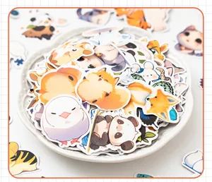Close-up view of a variety of cute cartoon animal stickers in a bowl for journal scrapbooking