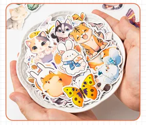 Close-up of a variety of cute cartoon animal stickers for journaling held in hands in a bowl