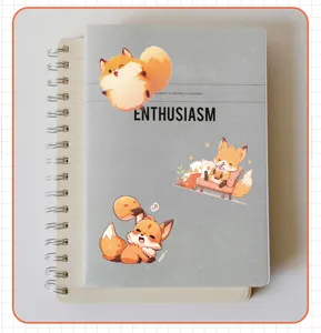 Close-up view of cute cartoon fox stickers applied on a grey hardcover notebook