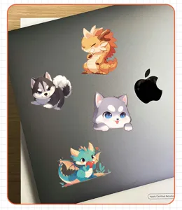 Close-up detail of cute cartoon animal stickers applied to a modern grey laptop surface
