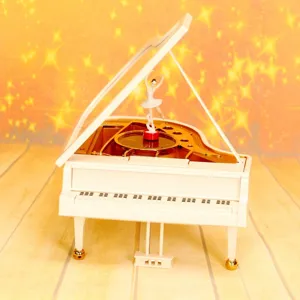 Detail einer weißen Flügel-Spieluhr mit rotierender Ballerina und Aufziehmechanismus