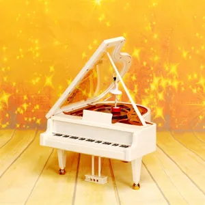 Detail einer weißen Klavier-Spieluhr mit einer rotierenden Ballerina-Figur im Inneren.