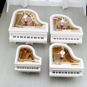Detailansicht von vier weißen Klavier-Spieluhren mit rotierenden Ballerina-Figuren