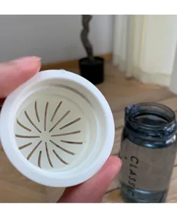Gedetailleerd overzicht van draagbare waterflesdeksel met filter en transparante beker.