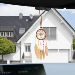 Handmade ethnic dreamcatcher car pendant with feathers hanging from the rearview mirror