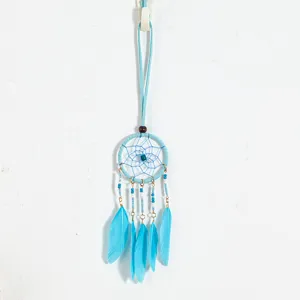 Detail view of ethnic style blue dreamcatcher pendant with delicate feathers and beads.