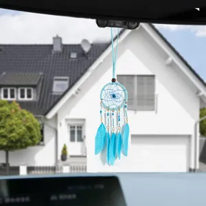 Light blue dreamcatcher pendant with soft feathers hanging on car rearview mirror