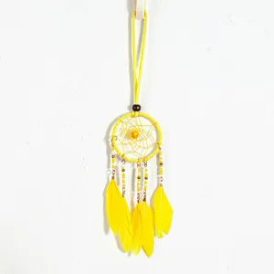 Close-up detail of yellow ethnic dreamcatcher necklace with vibrant feathers and beads