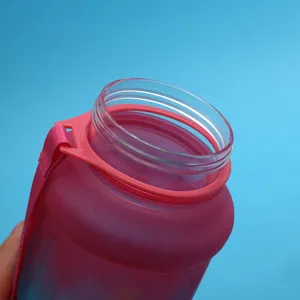 Close up view of the pink plastic sport water bottle rim showing portable strap attachment.