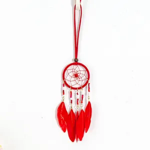Detailed macro view of a red ethnic style dreamcatcher necklace with feathers and tiny beads