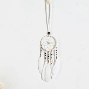 Macro view of a white ethnic-style dreamcatcher pendant with delicate feathers and beads