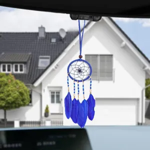 Close-up of a blue ethnic dreamcatcher hanging on a car rearview mirror as an ornament