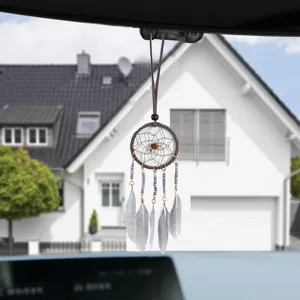Detail of handmade ethnic dreamcatcher car hanging ornament with grey feathers and beads.