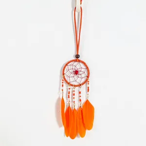 Macro view of bright orange feathers and beaded chain on a dreamcatcher pendant.
