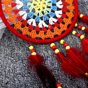 Gros plan détaillé d'un attrape-rêve tissé à la main avec plumes rouges et perles
