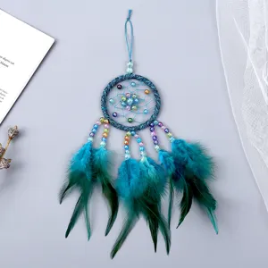 Adorno colgante atrapasueños azul con plumas y cuentas, detalle de decoracion de dormitorio.