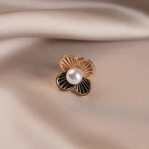 Close-up detail of an elegant vintage floral brooch with a white pearl center