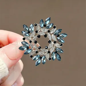 Detailed view of exquisite blue crystal rhinestone wreath brooch, elegant floral pin accessory.