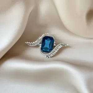Close-up of elegant brooch with large blue crystal and sparkling white zircons
