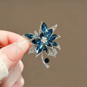 Elegant blue crystal brooch detail view, sparkling rhinestones, premium fashion jewelry accessory.