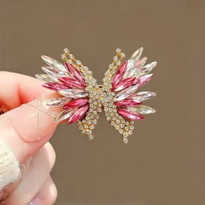 Close-up detail shot of exquisite pink crystal butterfly brooch accessory, sparkling rhinestone design.