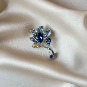 Close-up of elegant blue rhinestone flower brooch, vintage alloy crystal pin for women clothes.