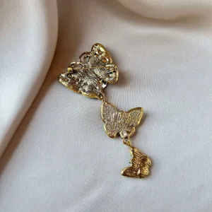 Detailed back view of a vintage gold alloy butterfly brooch with a secure pin clasp