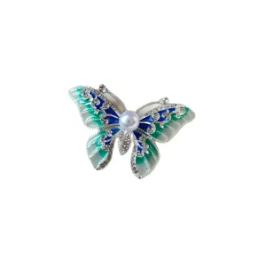 Elegant vintage butterfly brooch pin featuring colorful enamel details and central pearl